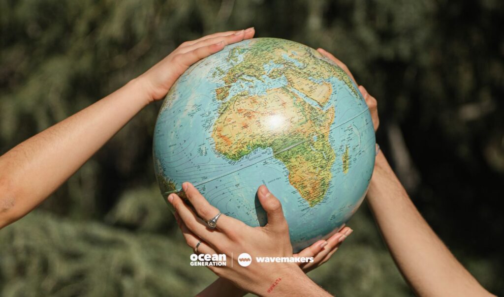 Hands holding up the planet carefully shared by Ocean Generation: an Ocean conservation charity in the UK.